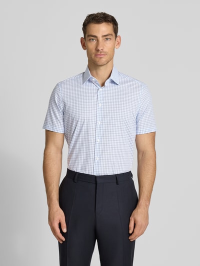 Männermodel trägt Regular Fit Business-Hemd aus Baumwolle mit Kentkragen von Christian Berg Men, feines Karo, Allover-Look, Ganzkörperansicht von vorne.