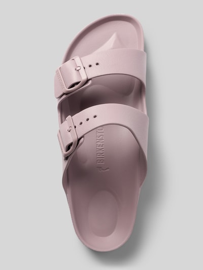 Produktfoto, Slides aus Leder mit Label-Prägung Modell 'ARIZONA EVA' von Birkenstock in zartem Rosa, abgerundete Form, profilierte Sohle, zwei Riemen mit Dornschließen, matt glatte Textur, Absatzhöhe 4 cm bei Größe 40.
