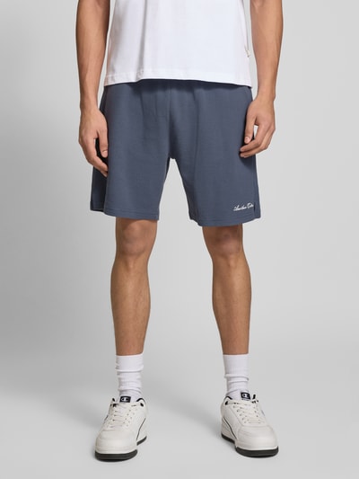 Männermodel trägt Shorts mit Logo-Print und Eingrifftaschen von ANOTHER COTTON LAB, Baumwoll-Mix, Lockerer-Schnitt, Nahaufnahme Oberkörper.