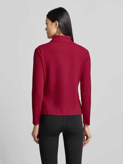 Frauenmodel trägt Slim Fit Trainingsjacke mit Logo-Print von Under Armour in Dunkelrot, glatte Struktur, Damen Trainingsjacke, Ganzkörperansicht Rückansicht.