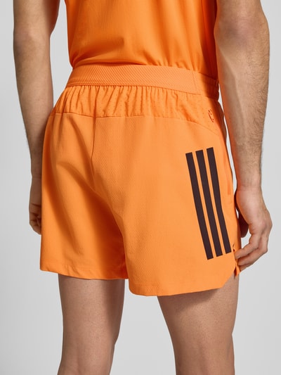 Männermodel trägt Regular Fit Shorts mit Logo-Print Modell 'Power' von adidas Training, Strukturmuster, elastischer Bund, Ganzkörperansicht Rückansicht.