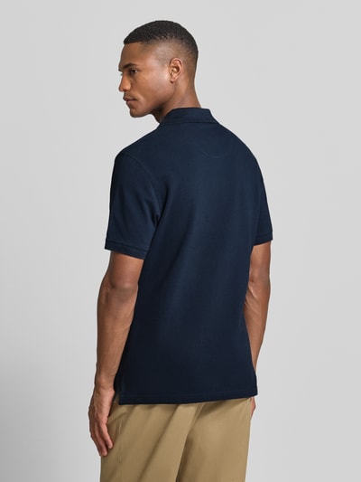 Männermodel trägt Regular Fit Poloshirt aus reiner Baumwolle von Barbour, Optik: Unifarben, Materialverarbeitung: Piqué, Ganzkörperansicht Rückansicht.