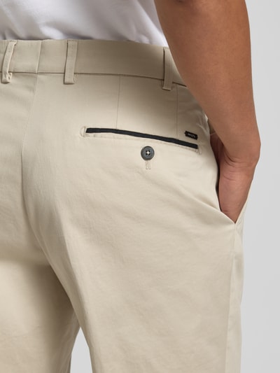 Männermodel trägt Chino mit Eingrifftaschen Modell 'Peaker' von Hiltl, beige, Baumwoll-Elasthan-Mix, Nahaufnahme Rückansicht.