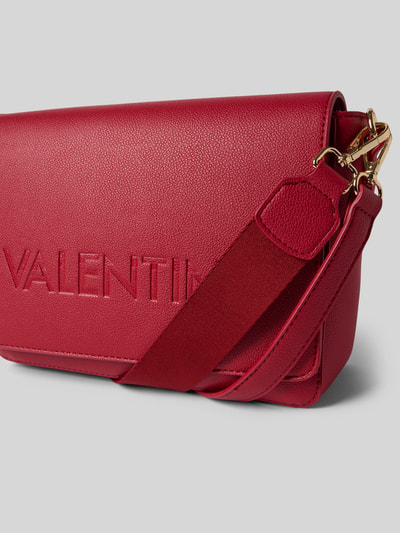 Produktfoto, torebka z logo model 'FOXY' od VALENTINO BAGS, kolor czerwony, fakturowana powierzchnia, szerokość w rozmiarze 1: 27 cm, długość w rozmiarze 1: 19 cm, głębokość w rozmiarze 1: 7 cm, długość paska na ramię w rozmiarze 1: 108 cm, główna przegroda z klapką i zapięciem na magnes, logo