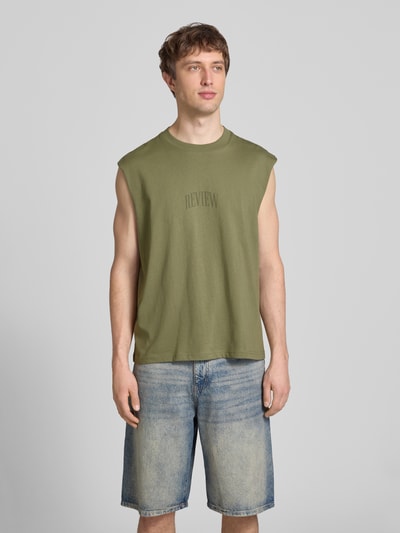 Männermodel trägt Muskelshirt mit Logo und Rundhalsausschnitt von REVIEW, grün, Reine Baumwolle, Regular-Fit, Logo, Ganzkörperansicht von vorne. Rückenlänge bei Größe M: 68 cm.