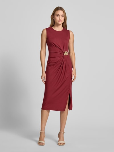 Frauenmodel trägt Slim Fit Midikleid aus Viskose-Mix mit Raffungen und floralem Zierbesatz von Christian Berg Woman Selection, ärmelloses-Design, Rundhalsausschnitt, tiefrote Farbe, glatte Textur, Seitenschlitz, Rückenlänge bei Größe 36: 115 cm, Brustweite bei Größe 36: 45 cm, Ganzkörperansicht von vorne.