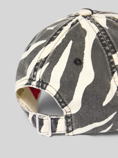 Frauenmodel trägt Basecap aus reiner Baumwolle Modell 'Ally-ZE' von HUGO mit Optik:Allover-Muster Animal-Print, Label-Stitching-Applikation, verstellbarem Riegel, Materialverarbeitung: Twill, Ganzkörperansicht Rückansicht.