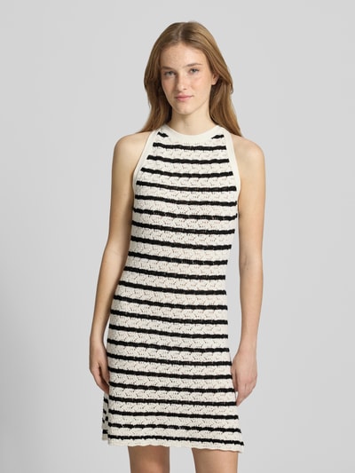 Vrouwenmodel draagt Knielanges Kleid in Strick-Optik van REVIEW, zwart-witte strepen, puur katoen, nauwsluitend, semi-transparant, mouwloos design, ronde hals, ruglengte maat S 92 cm, borstwijdte maat S 40 cm, tricotlook, fijn textuur. Ganzkörperansicht van voren.