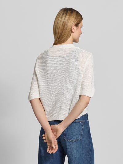 Modelka nosi kardigan mit V-Ausschnitt und 3/4-Arm von More & More, krój relaxed fit, listwa guzikowa, długość tyłu 48 cm, długość rękawów 24 cm, widok całej sylwetki z tyłu.