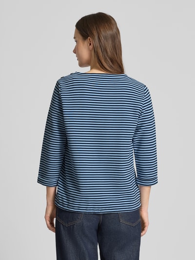 Frauenmodel trägt Regular Fit 3/4-Shirt aus Bio-Baumwoll-Mix von Tom Tailor mit Allover-Streifen, Knöpfen am Kragen, Rückansicht.