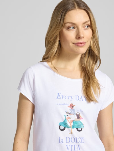 Frauenmodel trägt Damen T-Shirt aus Reine Baumwolle von Christian Berg Woman, weiß mit Rundhalsausschnitt, Print vorn, Rollsaum, Gerader-Schnitt, Rückenlänge 62 cm bei Größe S, Nahaufnahme Oberkörper.