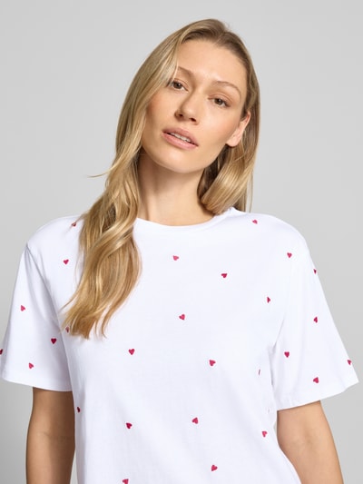 Frauenmodel trägt Boxy Fit T-Shirt aus reiner Baumwolle von Tom Tailor Denim, unifarben weiß mit roten Herz-Stickereien, Nahaufnahme Oberkörper.