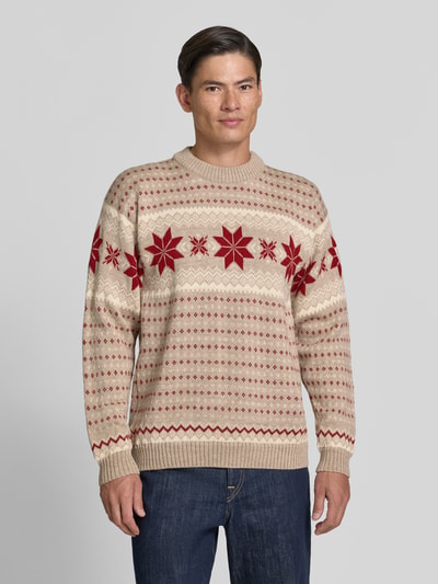 Männermodel trägt Regular Fit Wollpullover in Strick-Optik Modell 'Egersund' von Dale of Norway in Beige und Rot, reine Wolle, Ganzkörperansicht von vorne.