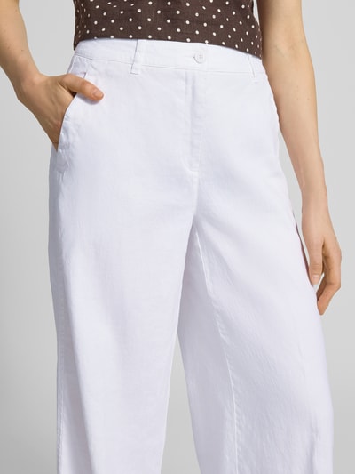 Frauenmodel trägt Leinenhose mit Eingrifftaschen Modell 'ADRIENNE' von Cambio aus Baumwolle-Leinen-Mix, ausgestellter Schnitt, Nahaufnahme Oberkörper. Bundweite bei Größe 36: 44 cm, Innenbeinlänge 83 cm, Knopf- und Reißverschluss, französische Eingrifftaschen, Gesäßtaschen.