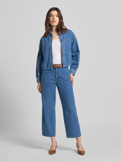 Frauenmodel trägt Straight Fit Jeans in verkürzter Passform Modell 'Estelle' von JOOP! aus Reiner Baumwolle in Blau, Eingriffstaschen, Knopf- und Reißverschluss, Ganzkörperansicht von vorne.