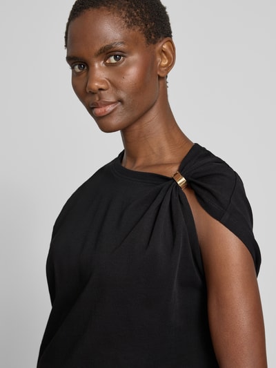 Frauenmodel trägt T-Shirt im One-Shoulder-Look Modell 'ALLIA' von Bash, Reine Baumwolle, Regular-Fit, schwarze Farbe, Nahaufnahme Oberkörper.