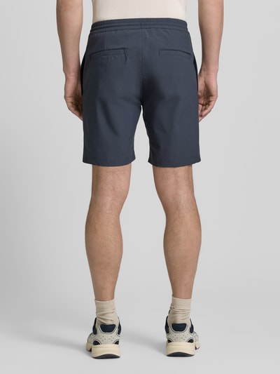 Männermodel trägt Straight Fit Shorts mit Eingrifftaschen Modell 'Drift' von SCANDINAVIAN EDITION, dunkelblau, elastischer Bund, Ganzkörperansicht Rückansicht.
