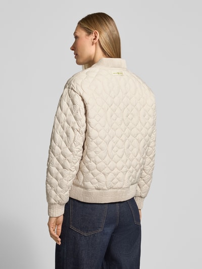 Frauenmodel trägt Jacke mit Stehkragen und Eingrifftaschen von Fuchs Schmitt, krój regular fit, pikowanie, stójka, listwa guzikowa, wpuszczane kieszenie, długość tyłu w rozmiarze 36: 58 cm, szerokość ramion w rozmiarze 36: 48 cm, szerokość klatki piersiowej w rozmiarze 36: 57 cm, długość rękawów w rozmiarze 36: 56 cm, jasny beż, geometryczne pikowanie, miękka tekstura, Ganzkörperansicht Rückansicht.
