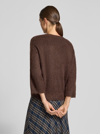 Frauenmodel trägt Strickjacke aus Woll-Mohair-Mix Modell 'Disille' von OPUS, braun, unifarben, Strickoptik, 3/4-Arm, gerippte Abschlüsse, Ganzkörperansicht Rückansicht.