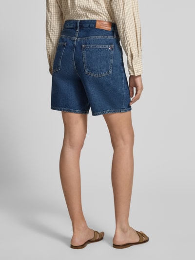 Frauenmodel trägt Straight Leg Bermudas aus reiner Baumwolle Modell 'EMI' von Tommy Hilfiger in Denim-Optik mit Label-Patch, Regular-Fit, 5-Pocket-Design, Ganzkörperansicht Rückansicht.