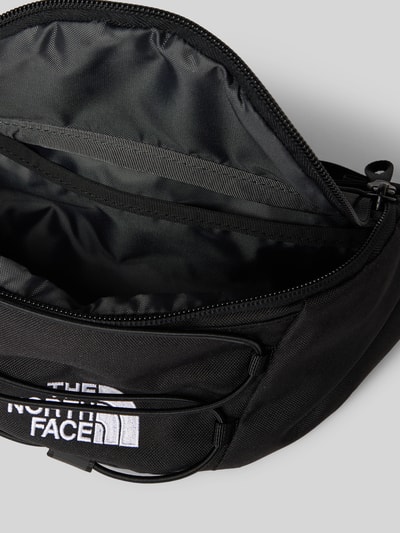 Produktfoto, schwarze Bauchtasche mit Label-Stitching Modell 'JESTER LUMBAR' von The North Face, Reißverschluss, Hauptfach, größenverstellbar, Maße: Breite 26 cm, Länge 17 cm, Tiefe 10 cm, Schulterriemen 50 cm.