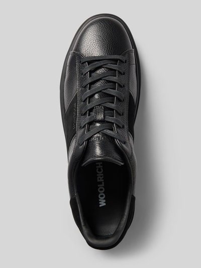 Produktfoto, Sneaker aus echtem Leder Modell 'Classic Court' von Woolrich, schwarze strukturierte Oberfläche, Schnürverschluss, strukturierte Sohle, abgerundete Form, Kontrastbesatz mit Label-Schriftzug, Absatzhöhe 4 cm, Schafthöhe 8 cm, Schaftweite 9 cm, Ansicht von oben.