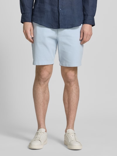 Männermodel trägt Modern Fit Chinoshorts aus Baumwoll-Mix Modell 'KANE1' von BOSS in Hellblau, unifarben, seitliche Eingrifftaschen, Ganzkörperansicht von vorne.