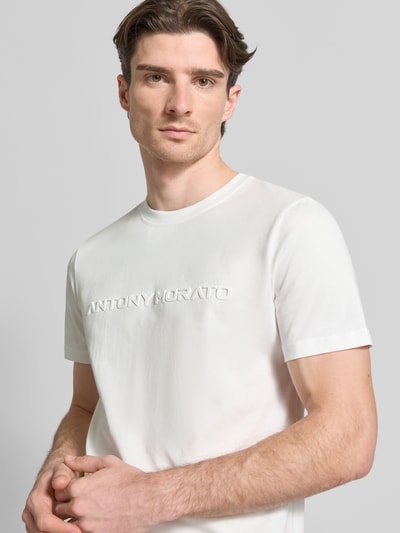 Männermodel trägt T-Shirt mit Label-Print van Antony Morato in wit, puur katoen, recht model, ronde hals, ruglengte 69 cm bij maat M, nahaufnahme bovenlichaam