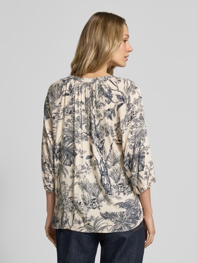 Frauenmodel trägt Relaxed Fit Bluse aus Viskose Modell 'CARLI' von Soyaconcept, creme mit blauem Allover-Look, Ganzkörperansicht Rückansicht.