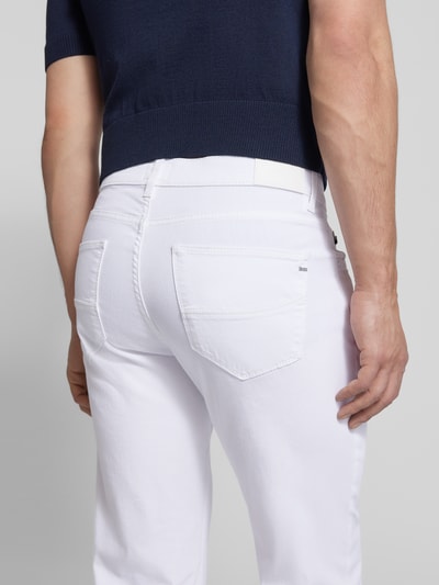 Männermodel trägt weiße Regular Fit Jeans im Used-Look Modell 'Cadiz' von BRAX aus Baumwoll-Mix mit Stretch-Anteil, Eingrifftaschen, Detailaufnahme Rückansicht.