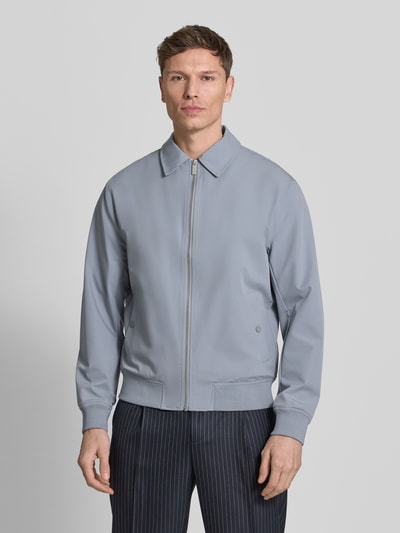 Męski model nosi Blouson mit Kentkragen od JAKE*S STUDIO MEN, szary kolor, krój regular fit, zapięcie na zamek, widok całej sylwetki z przodu. Szerokość w rozmiarze M: 58 cm, długość tyłu: 60 cm, szerokość ramion: 48 cm, długość rękawa: 67 cm.