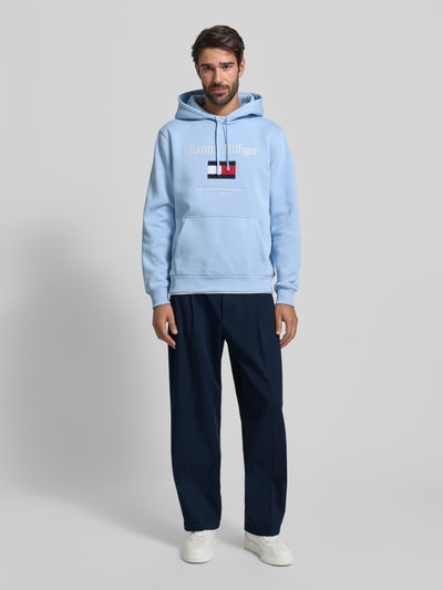 Męski model nosi Weite Fit Hose aus reiner Baumwolle Modell 'MURRAY' von Tommy Hilfiger, granatowe, unikolor, materiał bawełniany, kieszenie z tyłu i po bokach, naszywka z logo, szlufki na pasek. Ganzkörperansicht von vorne.