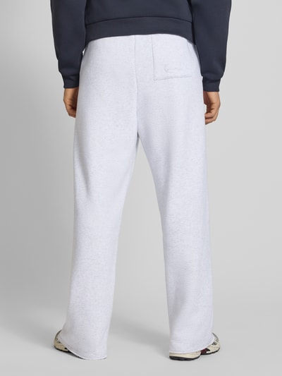 Männermodel trägt Straight Leg Sweatpants mit elastischem Bund von KARL KANI aus Baumwoll-Mix, Gesäßtasche, hellgrau, Ganzkörperansicht Rückansicht. Innenbeinlänge bei Größe M: 39 cm.