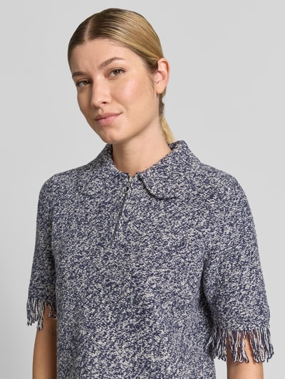 Frauenmodel trägt Strickshirt mit Reißverschluss und Fransen von Christian Berg Woman im Baumwoll-Mix mit Umlegekragen und kurzen Ärmeln, Nahaufnahme Oberkörper.