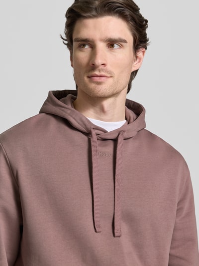 Männermodel trägt Regular Fit Hoodie aus reiner Baumwolle Modell 'DAPO' von HUGO, Optik: Unifarben, Sweatstruktur, Nahaufnahme Oberkörper.