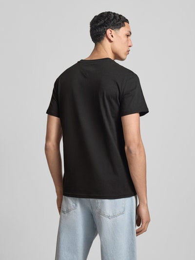 Männermodel trägt Herren T-Shirt von Tommy Jeans, Modell 'LINEAR CHEST TEE', Optik: Unifarben, Passform: Regular-Fit, reine Baumwolle, Ganzkörperansicht Rückansicht