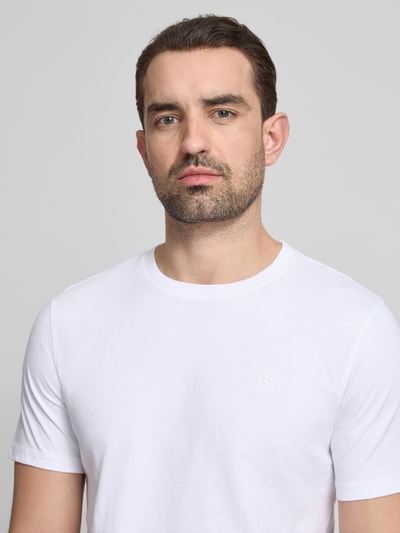 Männermodel trägt T-Shirt mit Label-Stitching und Rundhalsausschnitt von Scotch & Soda in Weiß, Reine Baumwolle, Regular-Fit, Nahaufnahme Oberkörper. Rückenlänge bei Größe M: 68 cm.