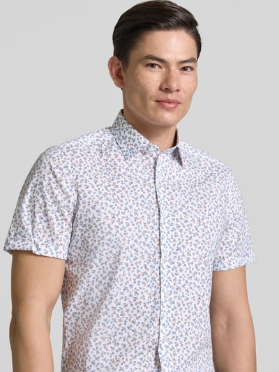 Männermodel trägt Slim Fit Freizeithemd mit floralem Allover-Print von OLYMP Level Five, elastischer Baumwoll-Mix, Nahaufnahme Oberkörper.