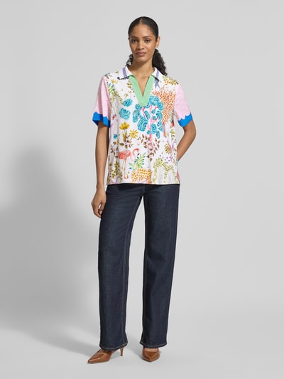 Vrouwenmodel draagt Blusenshirt aus Seide-Elasthan-Mix im Allover-Look van HERZENS, regular fit, omgeslagen kraag, V-hals, kleurrijk dessin, ruglengte 66 cm, mouwlengte 25 cm, voorkant volledig zichtbaar, frontaal gezien.