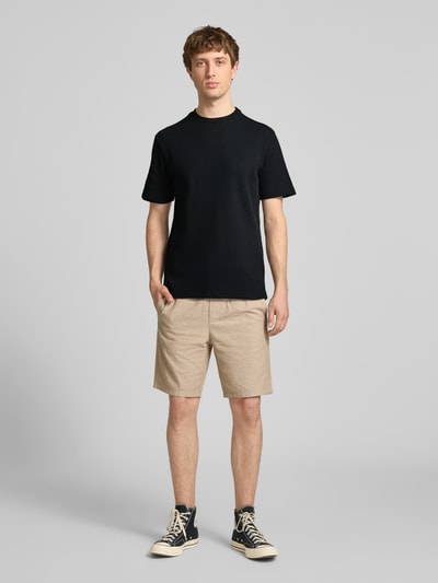 Männermodel trägt Regular Fit T-Shirt aus Baumwoll-Mix Modell 'TOBIE' von Only & Sons, unifarben mit Waffel-Struktur, Ganzkörperansicht von vorne.
