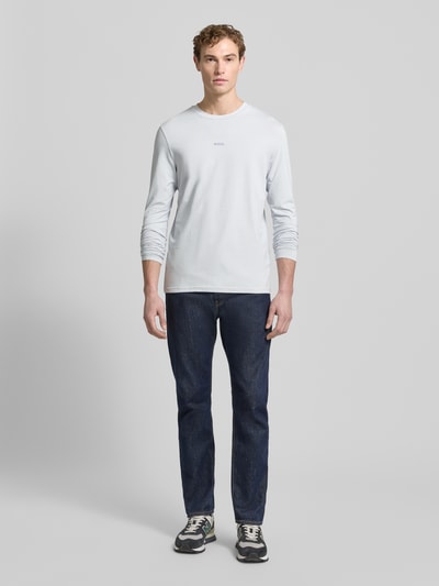 Männermodel trägt Regular Fit Langarmshirt aus Baumwoll-Mix Modell 'TCHARK' von BOSS Orange, Optik: Unifarben, Ganzkörperansicht von vorne.