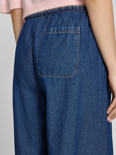 Frauenmodel trägt Pull-on-Jeans mit weitem Bein und Kordelzug von REVIEW aus reiner Baumwolle, blaue Farbe, Gesäßtasche, Detailaufnahme Rückansicht.