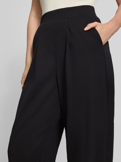 Frauenmodel trägt Relaxed Fit Anzughose mit Bundfalten Modell 'SC-SIHAM 103' von Soyaconcept, schwarze Farbe, Nahaufnahme Oberkörper, Damen Anzughose von Soyaconcept.