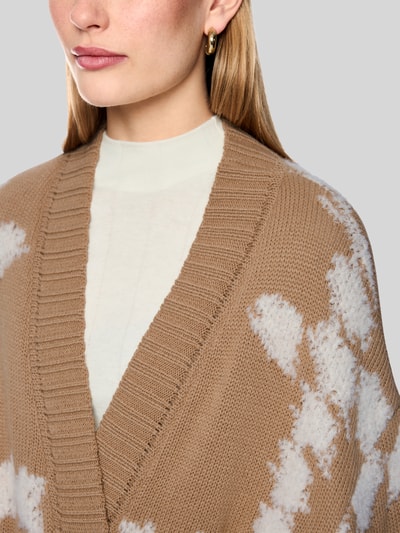 Vrouwenmodel draagt cardigan met bindegordel en 3/4-mouw van Marc Cain, materiaalmix met alpaca, all-over look, regular fit, detailopname bovenlichaam.
