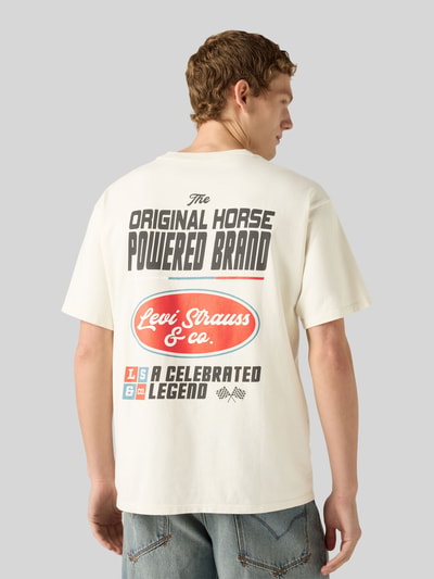Männermodel trägt Relaxed Fit T-Shirt aus reiner Baumwolle von Levi's®, cremefarben mit großem Print, lockere Form, Ganzkörperansicht Rückansicht.