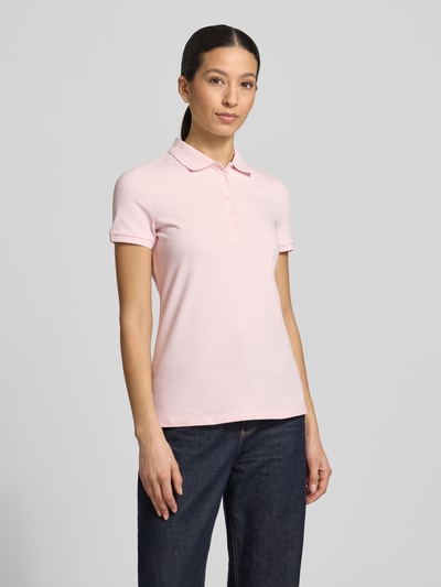Frauenmodel trägt Slim Fit Poloshirt mit Knopfleiste von Christian Berg Woman im Baumwoll-Elasthan-Mix mit Seitenschlitze, hellrosa, Ganzkörperansicht von vorne. Rückenlänge bei Größe S: 62 cm.
