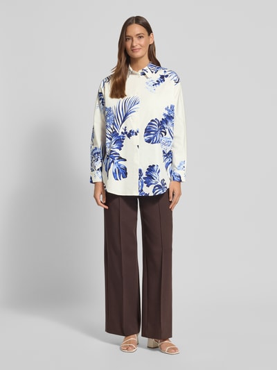 Vrouwenmodel draagt Regular Fit Bluse im Allover-Look Modell 'BATWING TROPICS' van Fynch-Hatton van zuivere katoen, blousekraag, knoopsluiting, wit met blauwe tropische print, lengte rugzijde maat 36: 46 cm, mouwlengte maat 36: 50 cm, volledige lichaamsaanzicht van voren.