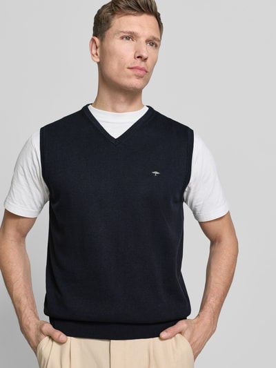 Männermodel trägt Pullunder mit Label-Stitching von Fynch-Hatton in Dunkelblau, Reine Baumwolle, Regular-Fit, V-Ausschnitt, Ganzkörperansicht von vorne.