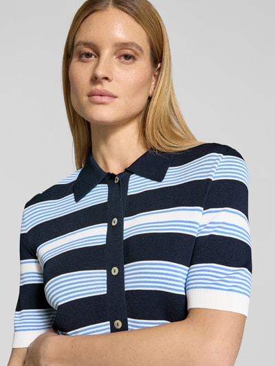 Modelka nosi Regular Fit Poloshirt aus Viskose-Mix mit Knopfleiste von Christian Berg Woman Selection, paski granatowe, błękitne i białe, miękka faktura, krój regular fit, listwa guzikowa, rękaw o dł. 1/2, długość tyłu w rozmiarze 36: 49 cm, długość rękawów w rozmiarze 36: 26 cm, mieszanka wiskozy, zbliżenie na górną część sylwetki
