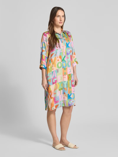 Kobiece model prezentuje Relaxed Fit Hemdblusenkleid aus reiner Viskose von Milano Italy, kolorowy nadruk, kołnierzyk koszulowy, zapięcie na guziki, rękaw 3/4, długość tyłu w rozmiarze 36: 97 cm, szerokość w rozmiarze 36: 48 cm, długość rękawa w rozmiarze 36: 43 cm, widok całej sylwetki z przodu.
